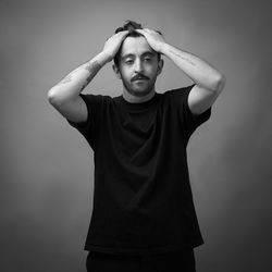 Portrait of young man standing against wall