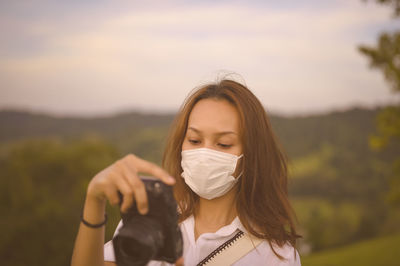 Young woman traveller checking her camera