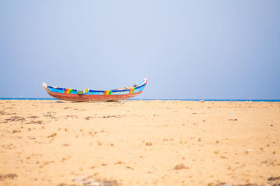 Boat on beach against clear sky