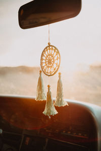 Close-up of electric lamp hanging against window