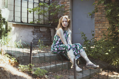 Woman looking away and sitting on doorstep scenic photography