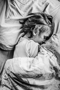 High angle view of girl sleeping on bed