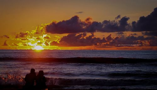 Silhouette people on beach against sky during sunset