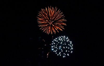 Low angle view of fireworks in sky at night