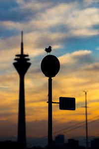 Low angle view of street light against dramatic sky