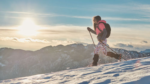 Downhill in the snow a girl with crampons and gaiters