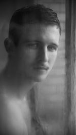 Close-up of boy looking through window