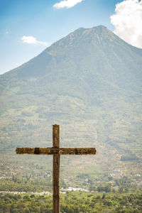 Cross on mountain against sky