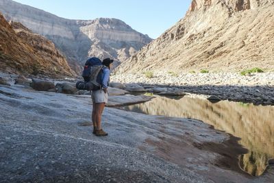 Rear view of woman standing on rock