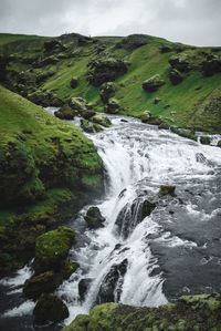 Scenic view of waterfall against sky
