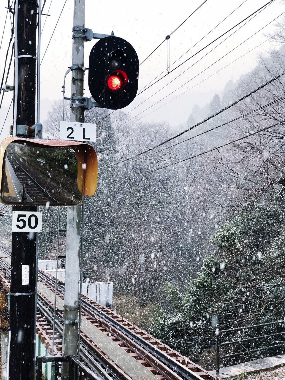 RAILROAD TRACK ON SNOW COVERED LANDSCAPE