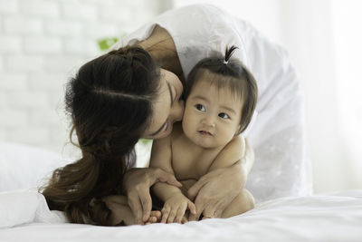 Portrait of mother with baby on bed