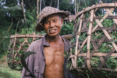 Horizontal portrait of south asian balinese senior men wearing traditional cone-shaped hat against. 