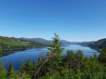 Scenic view of lake against clear blue sky