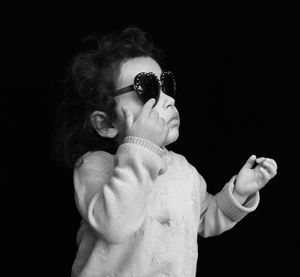 Girl wearing sunglasses against black background