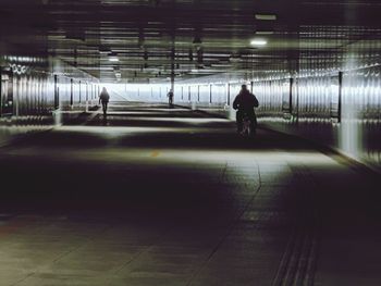 Rear view of man walking in subway tunnel