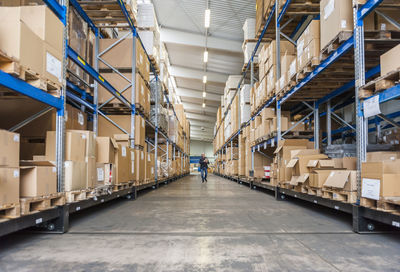 Manager checking goods in storage hall of factory