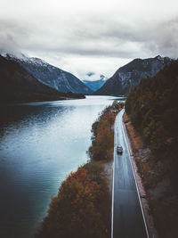 Scenic view of lake by mountains against sky