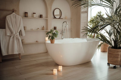 Luxury interior of big bathroom at modern african style with oval bathtub in natural lighting