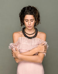 Beautiful woman standing against gray background