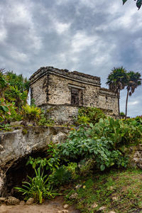Low angle view of old building against cloudy sky