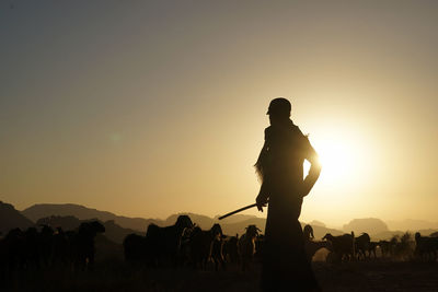 Silhouette of a shepherd at sunset