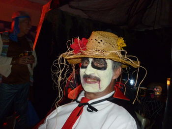 Portrait of mid adult man with painted face wearing halloween costume