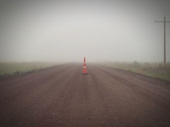 Road amidst foggy landscape against sky