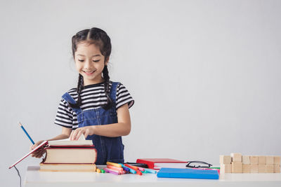 Full length of girl looking at book