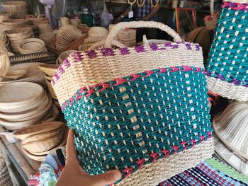 Midsection of woman in basket for sale at market stall