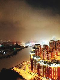 High angle view of illuminated buildings against sky at night