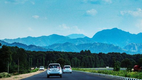 Cars on road against mountain range