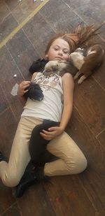 High angle portrait of young woman lying down on floor at home