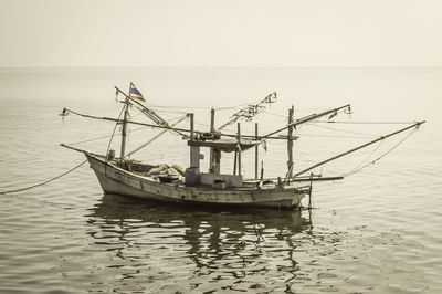 Fishing boat in sea against clear sky