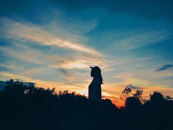 Low angle view of silhouette statue against sky at sunset