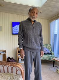 Portrait of senior man standing against the wall