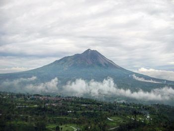 Scenic view of mountain range against cloudy sky