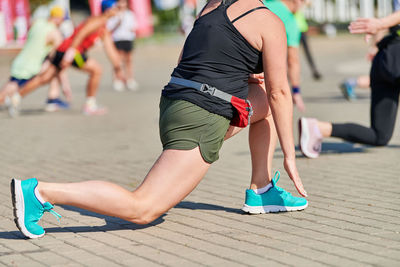 Young woman warming up before running marathon. beautiful girl with tan legs. outdoor fitness