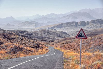 Road leading towards mountains against sky