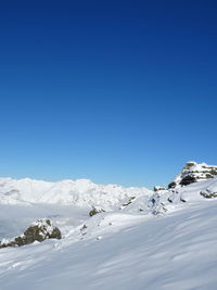 Scenic view of snowcapped mountains against clear blue sky