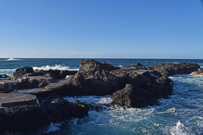 Scenic view of sea against clear blue sky