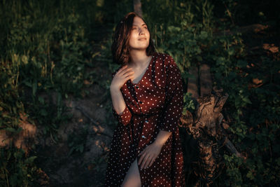 Young woman looking away while standing on land