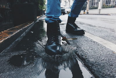 Low section of person stepping in water puddle