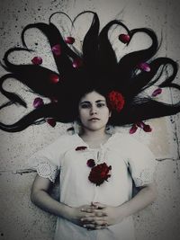 Portrait of beautiful young woman standing against red wall