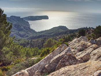 High angle view of rocks by sea against sky