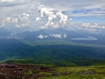 Scenic view of sea and mountains against cloudy sky