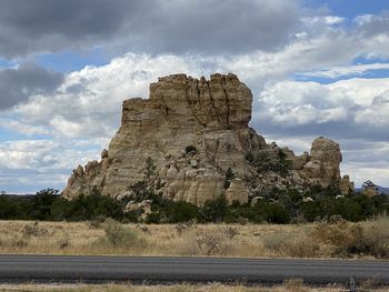 Rock formations on landscape against cloudy sky