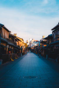 Street amidst buildings in town against sky