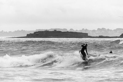 Silhouette men surfing in sea