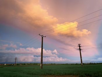 Transmission towers on a field on a stormy day with beautiful clouds